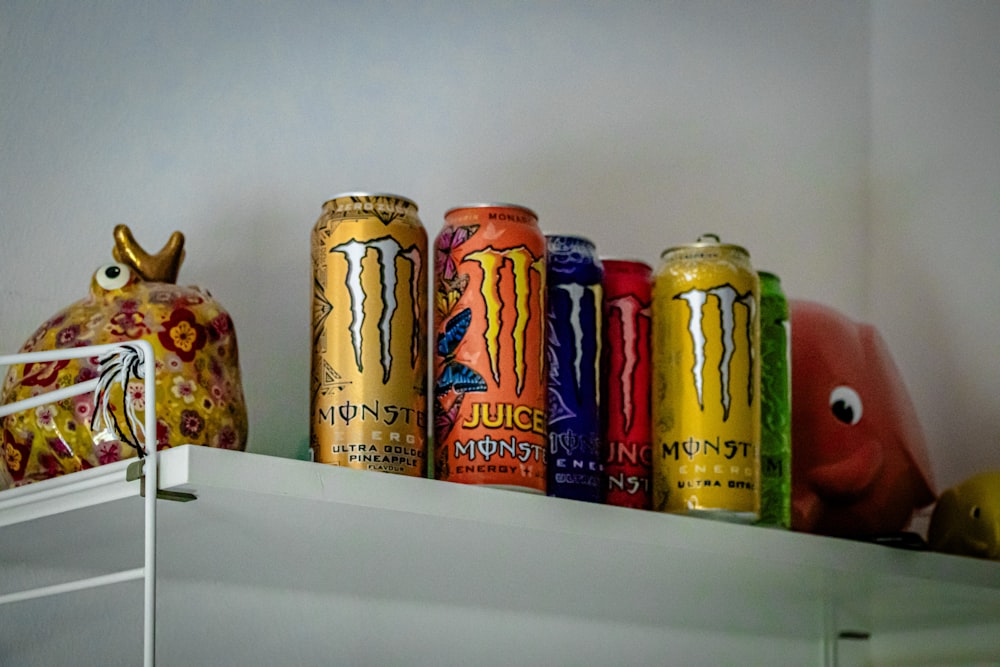 a shelf filled with cans of monster energy drinks