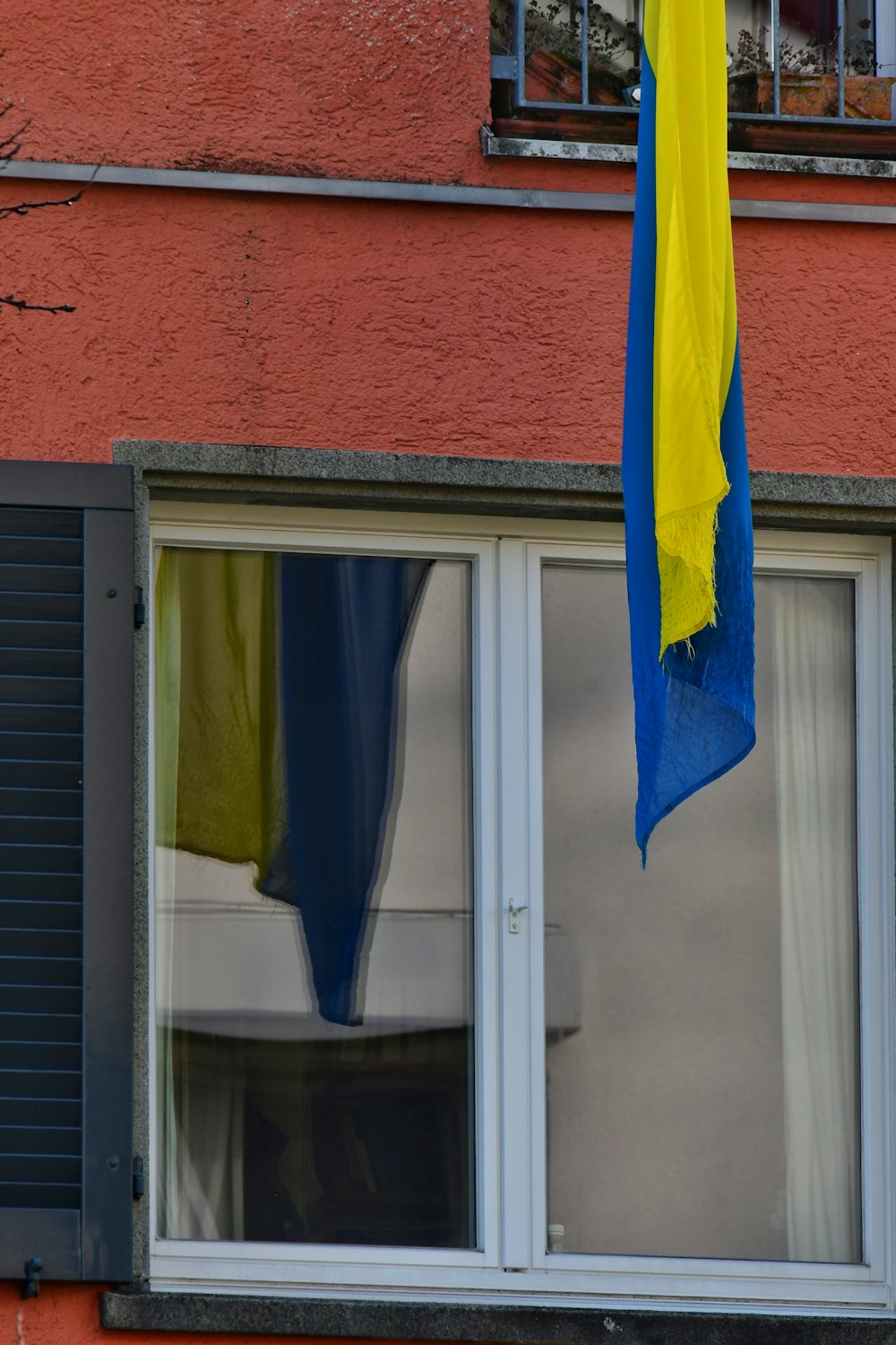 a blue and yellow umbrella hanging from a window