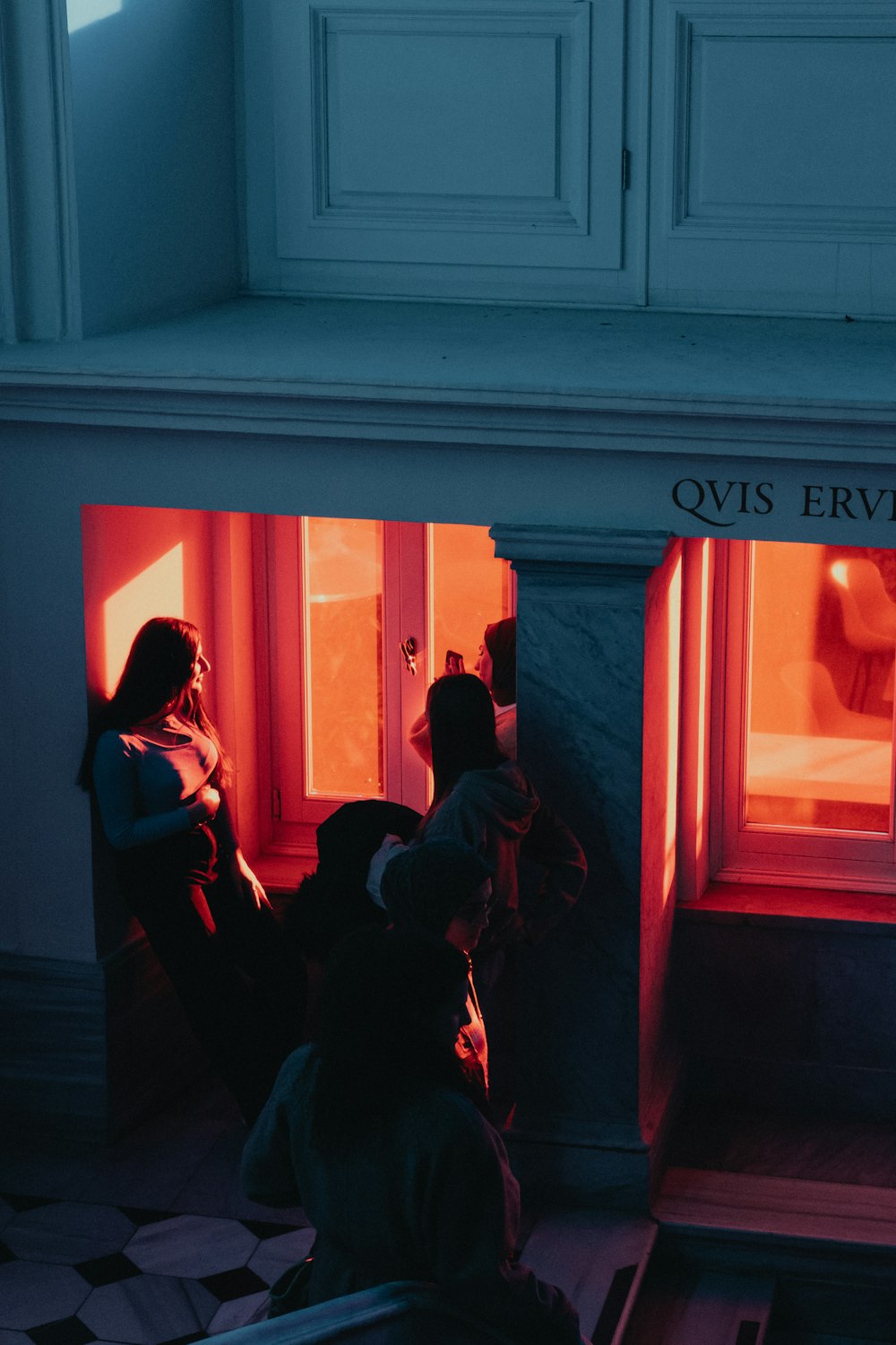 a couple of people sitting in front of a window