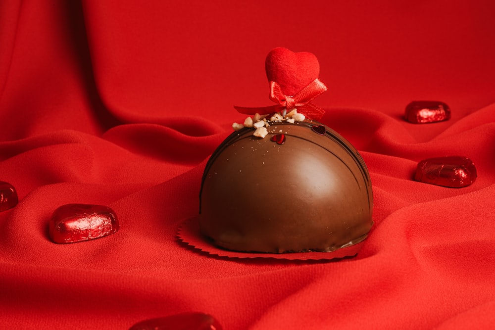 a heart shaped chocolate on a red cloth