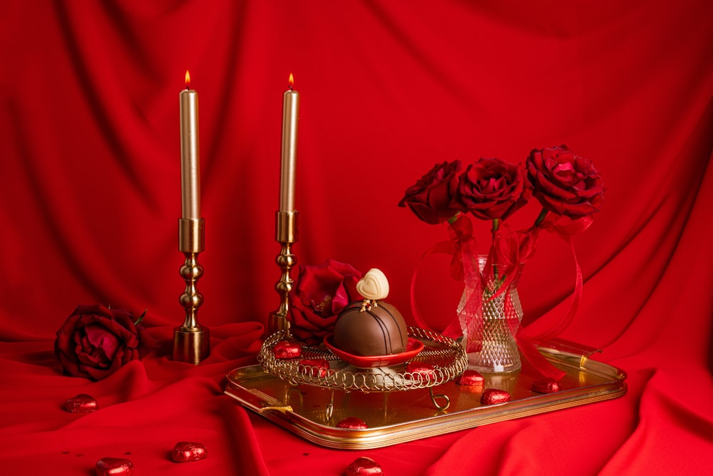 a table topped with a tray covered in chocolates and roses