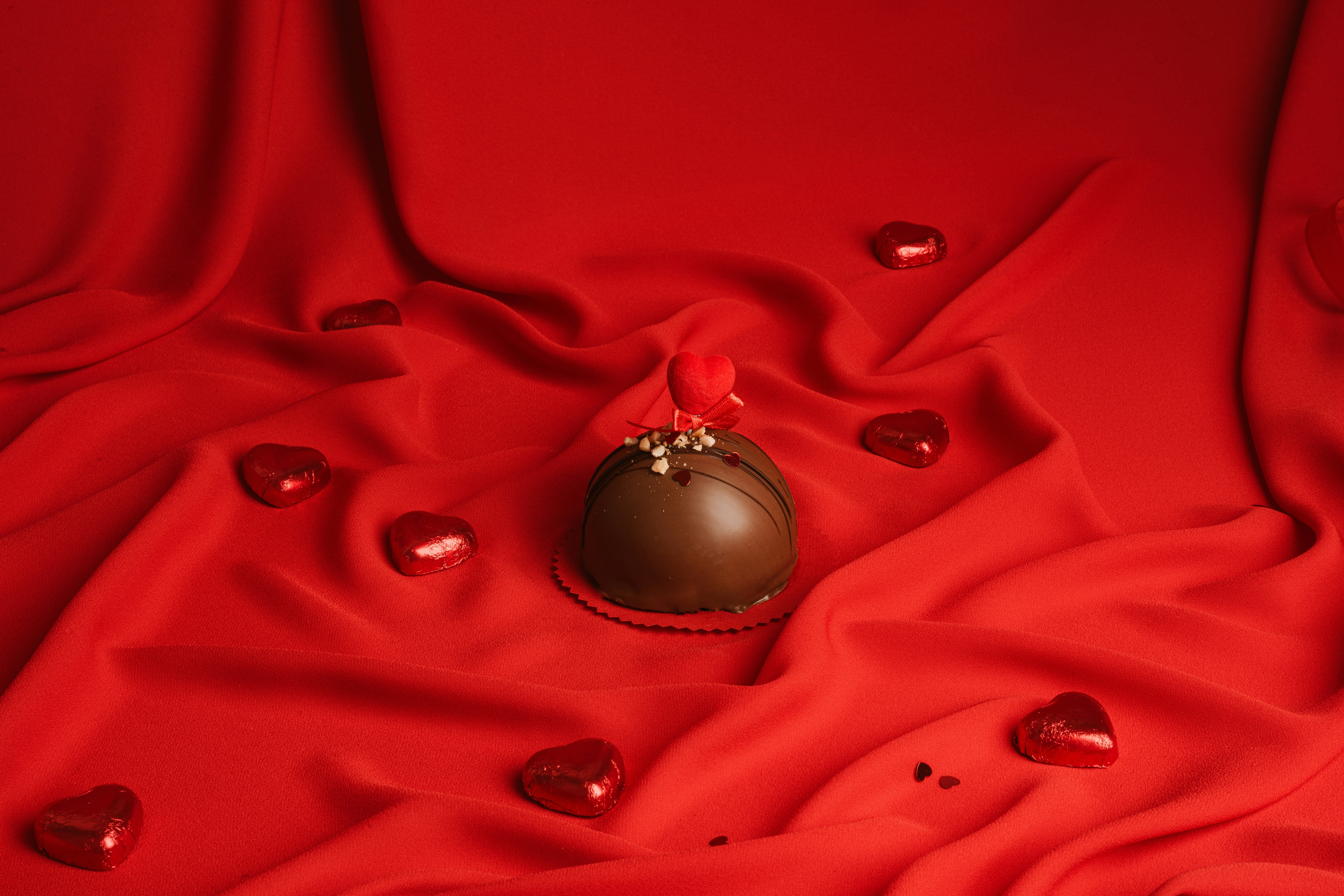 un cioccolatino a forma di cuore su un canovaccio rosso