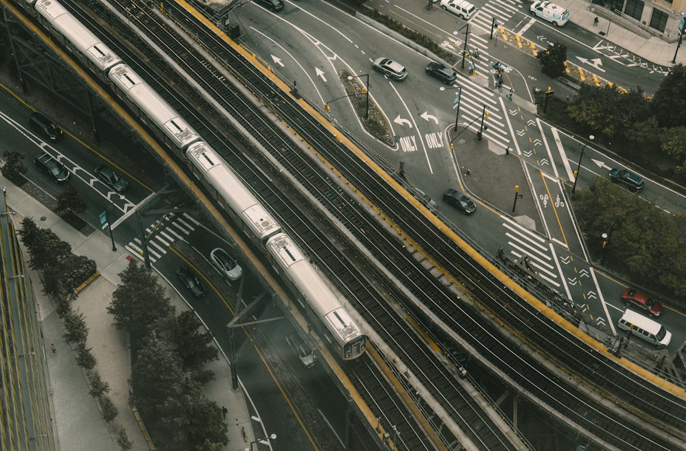 an aerial view of a city street with a train on the tracks