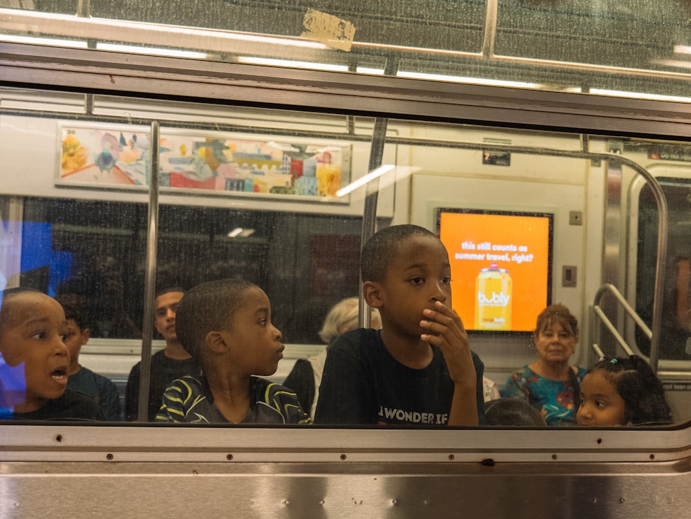 a group of children sitting on a subway train