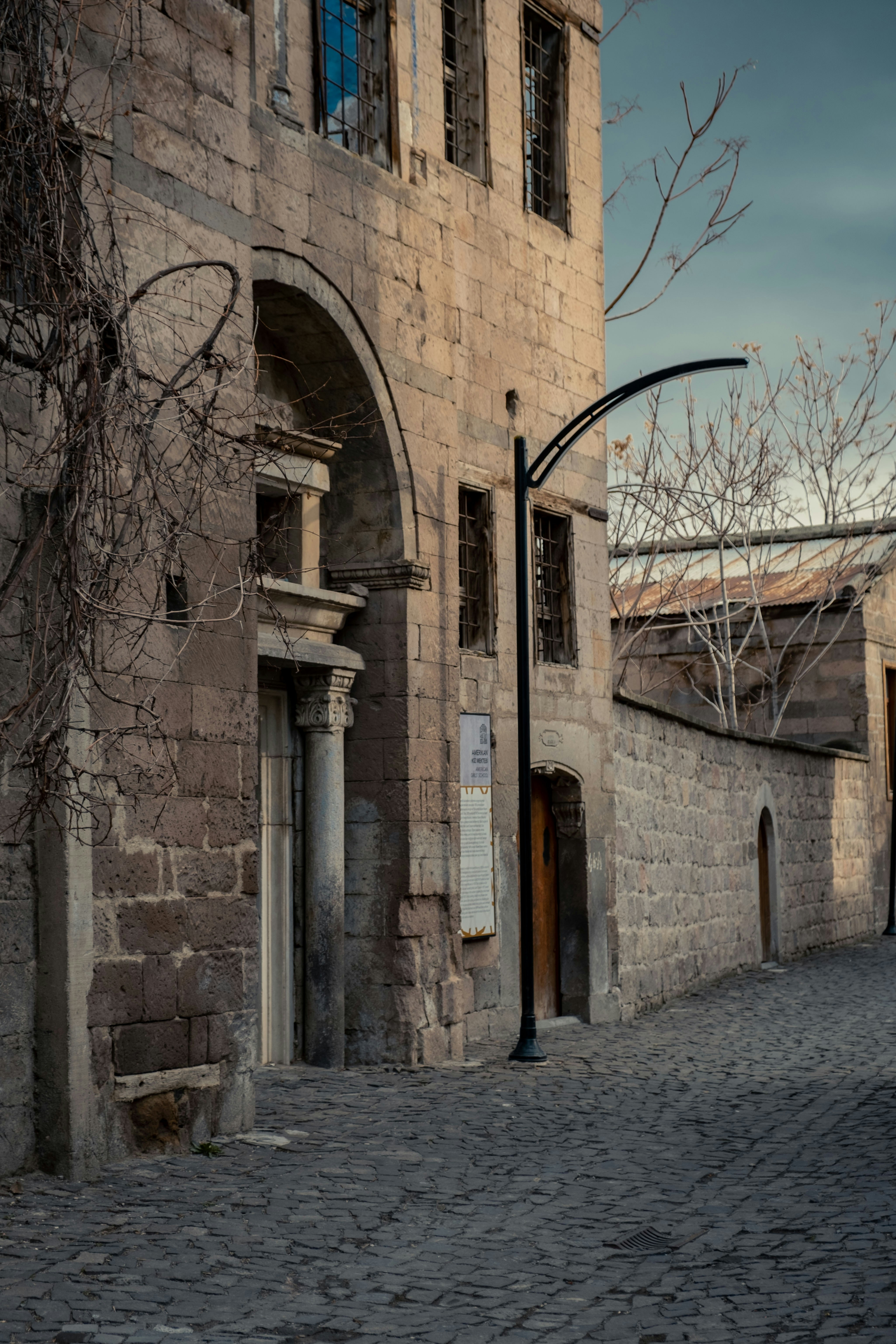 A street light sitting on the side of a brick building photo – Free ...