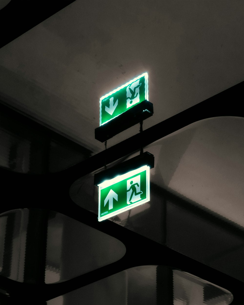 a couple of green street signs hanging from a ceiling