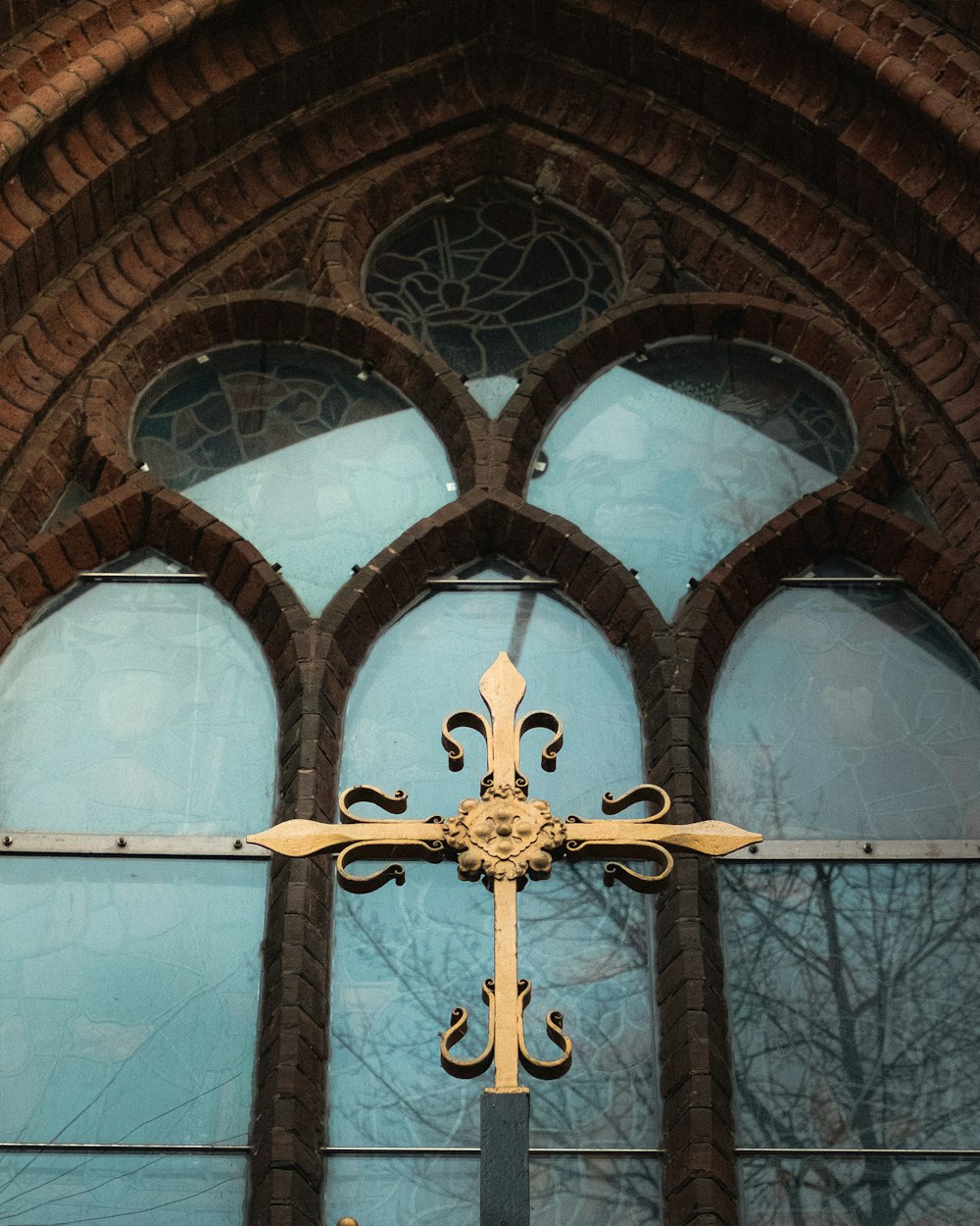 a cross on a wall in front of a window