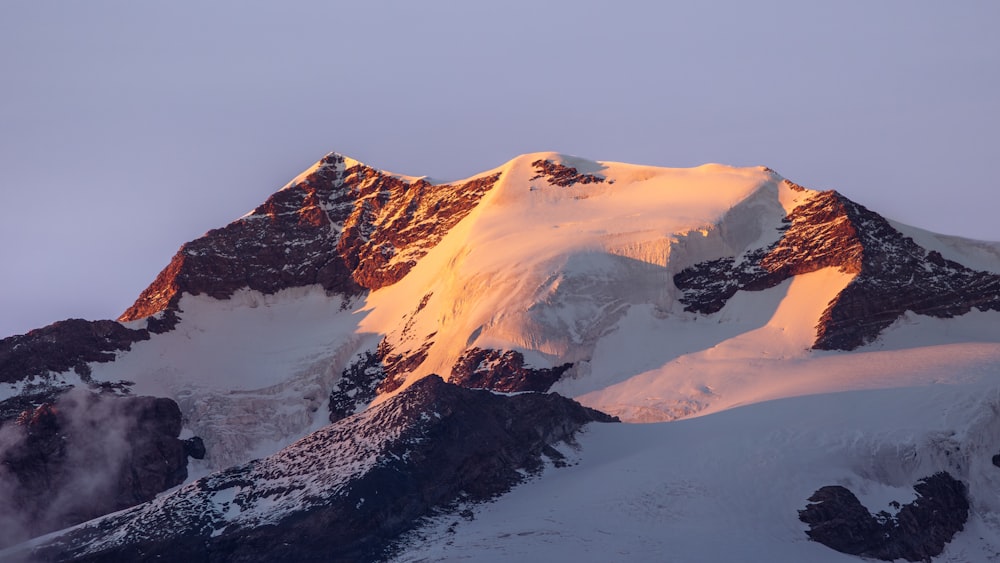 a snow covered mountain with a very tall peak