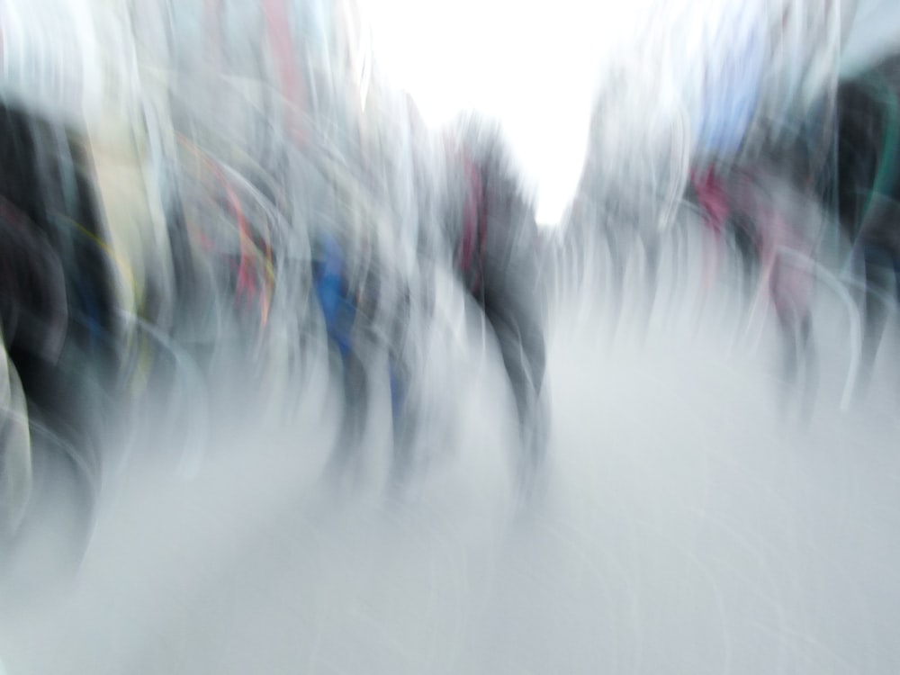 uma foto desfocada de um grupo de pessoas caminhando por uma rua