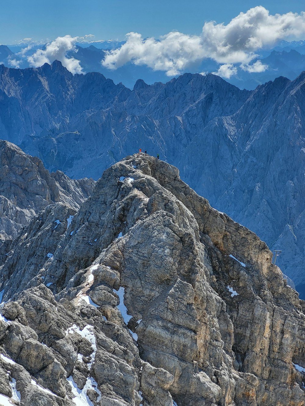 a man standing on top of a mountain on top of a snow covered slope