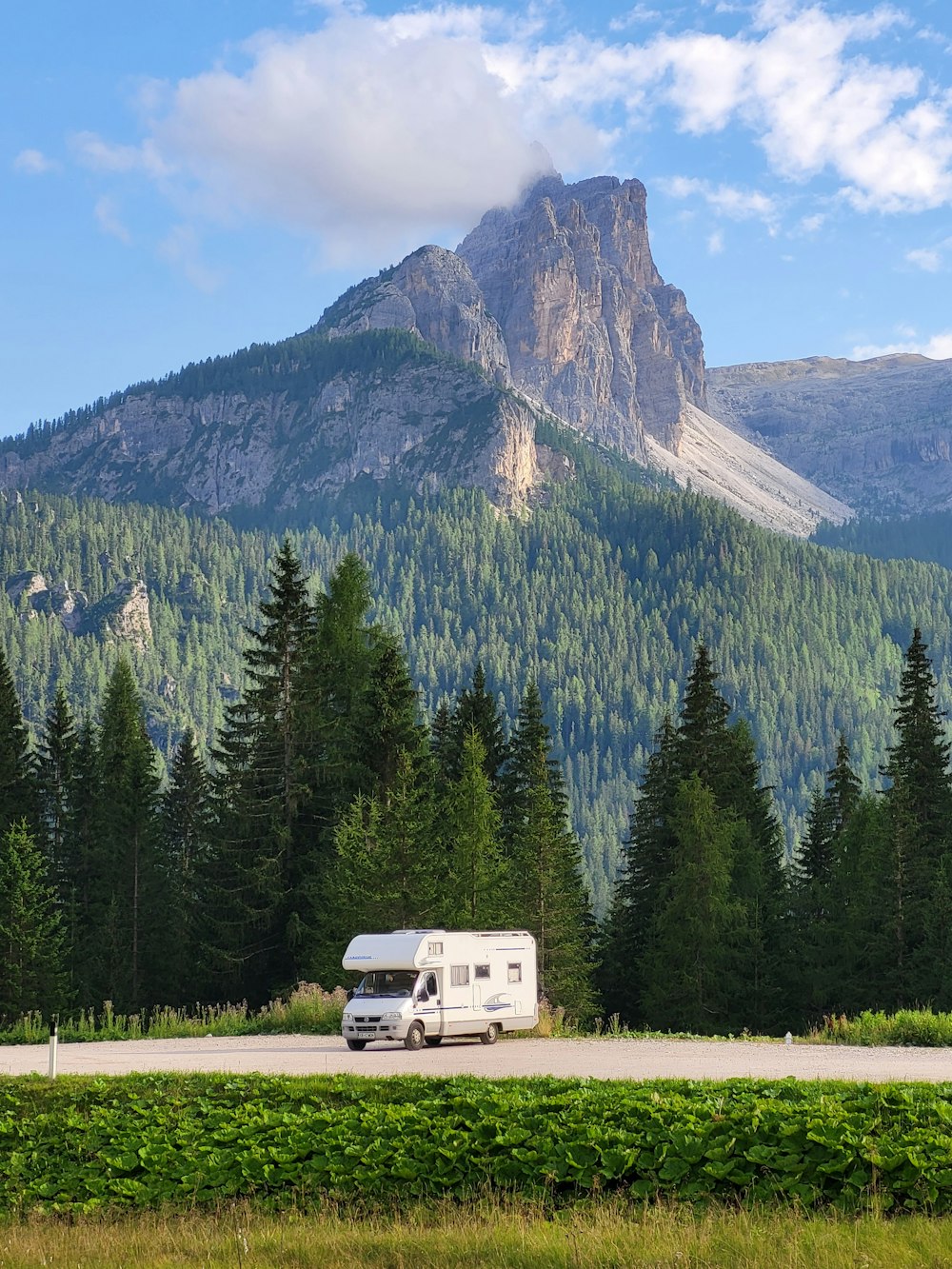 a motor home is parked in front of a mountain