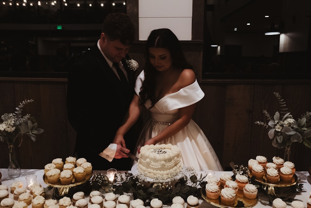 a man and a woman cutting a wedding cake