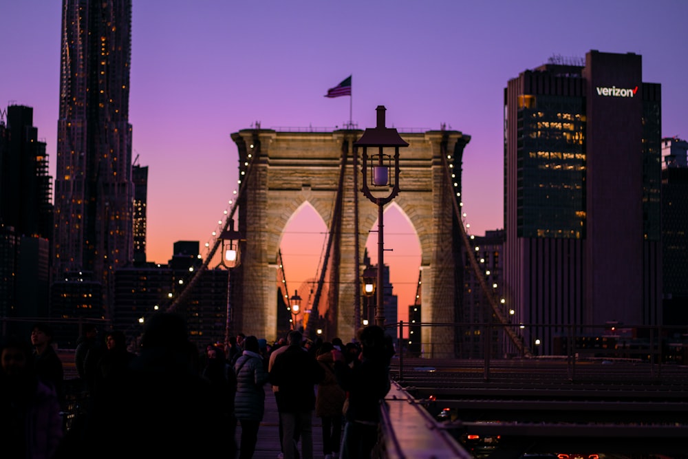 a group of people walking across a bridge