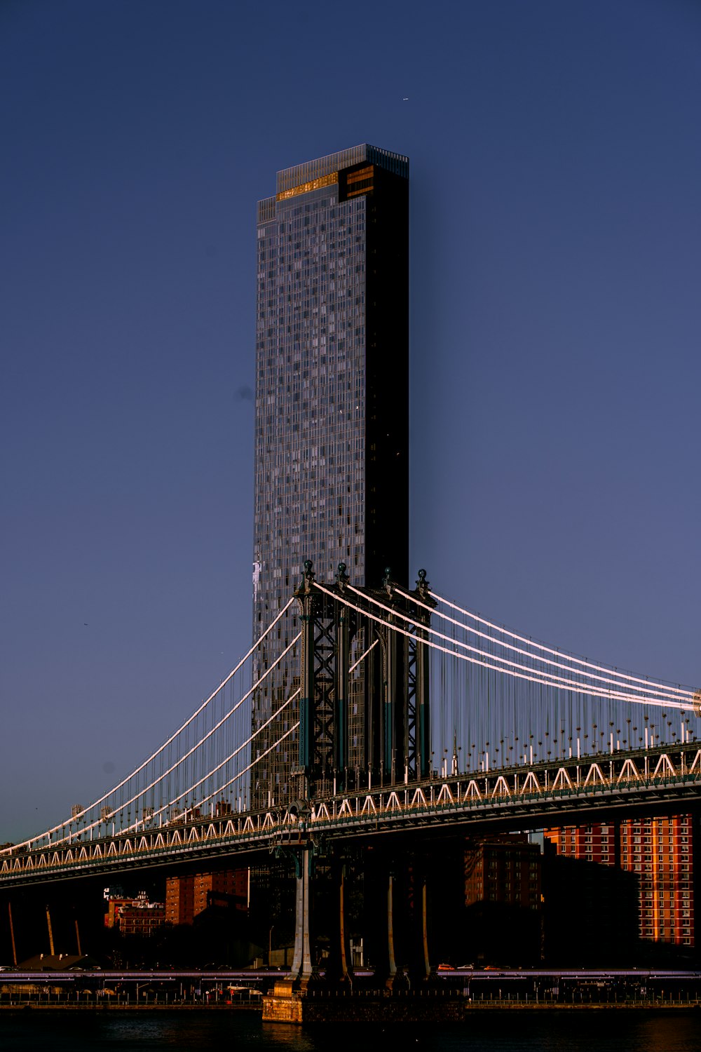 a large bridge crossing over a river next to a tall building