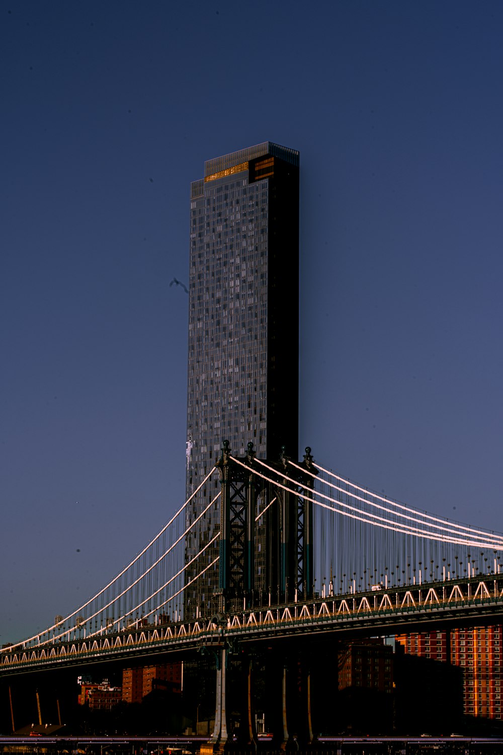 a large bridge crossing over a river next to a tall building