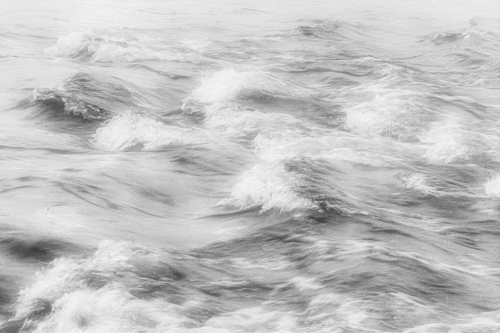 Uma foto em preto e branco das ondas no oceano