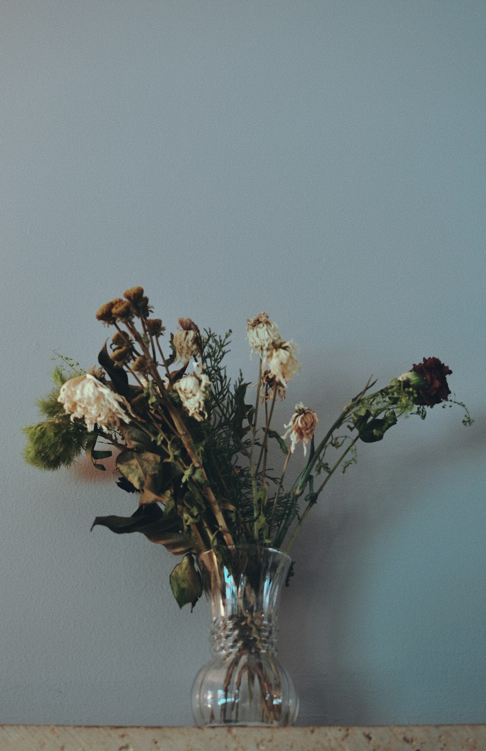 un vase rempli de beaucoup de fleurs sur le dessus d’une table
