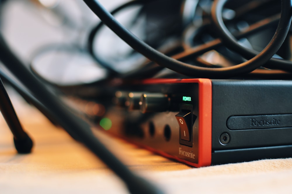 a close up of a black and red device on a table