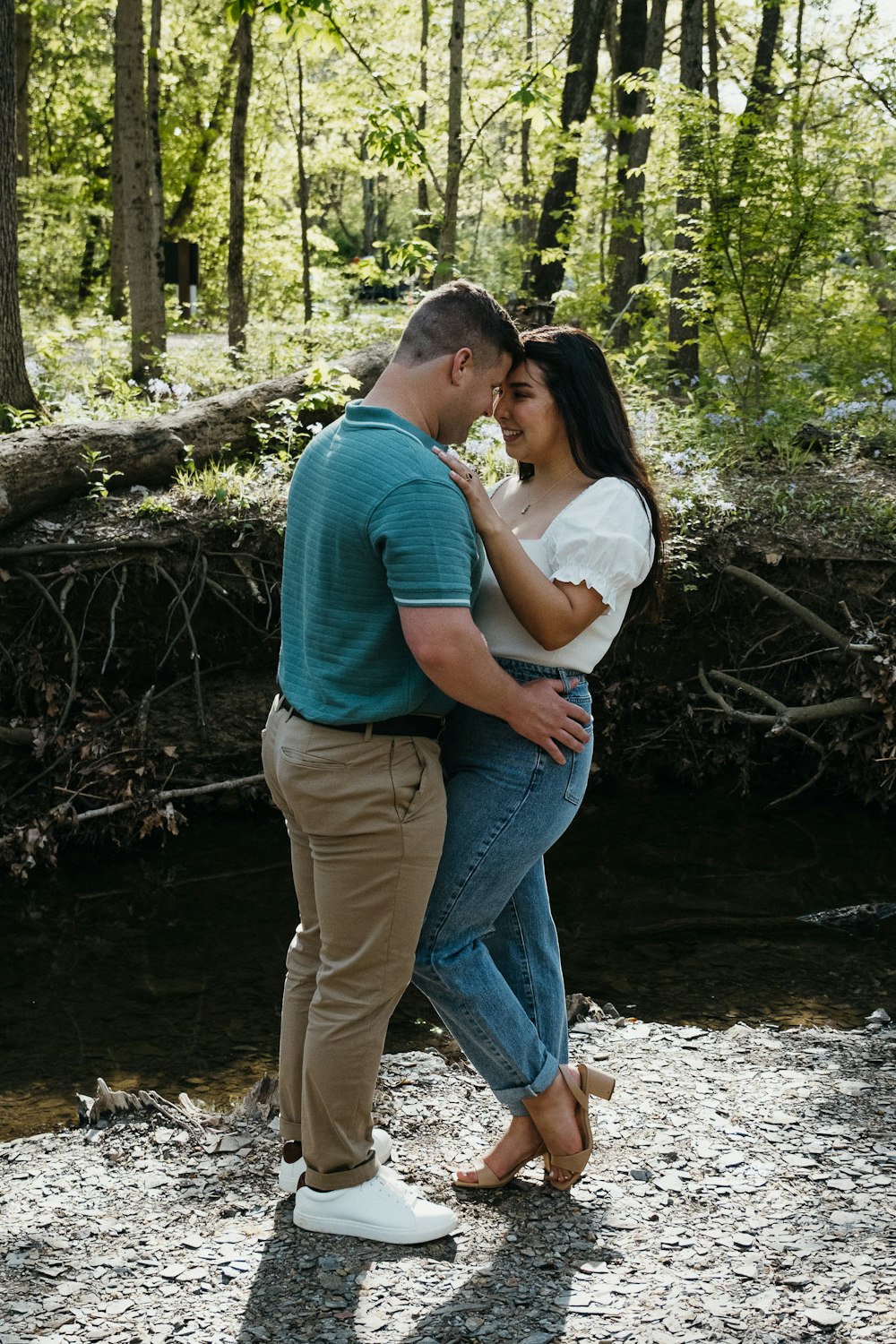 a man and a woman standing next to each other near a river