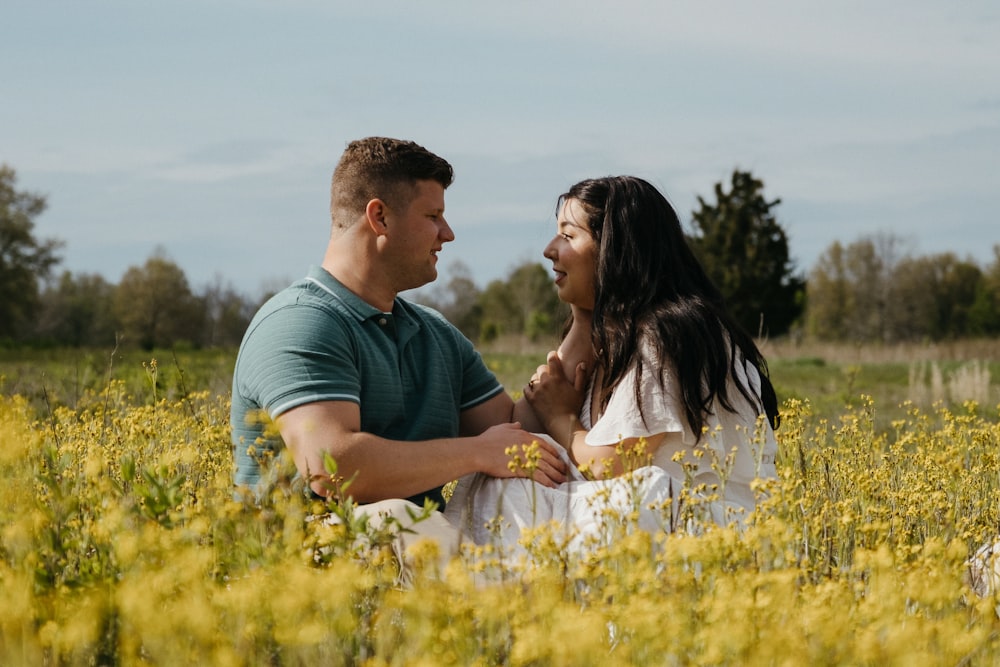 a man and a woman sitting in a field of flowers