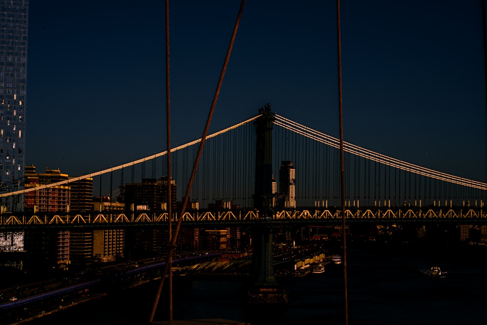 a view of a bridge at night with a city in the background