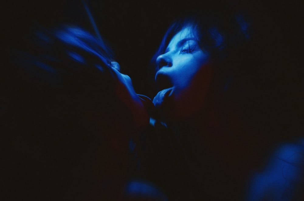 a woman with her eyes closed in the dark