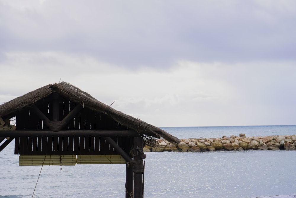 a small hut sitting on top of a beach next to the ocean