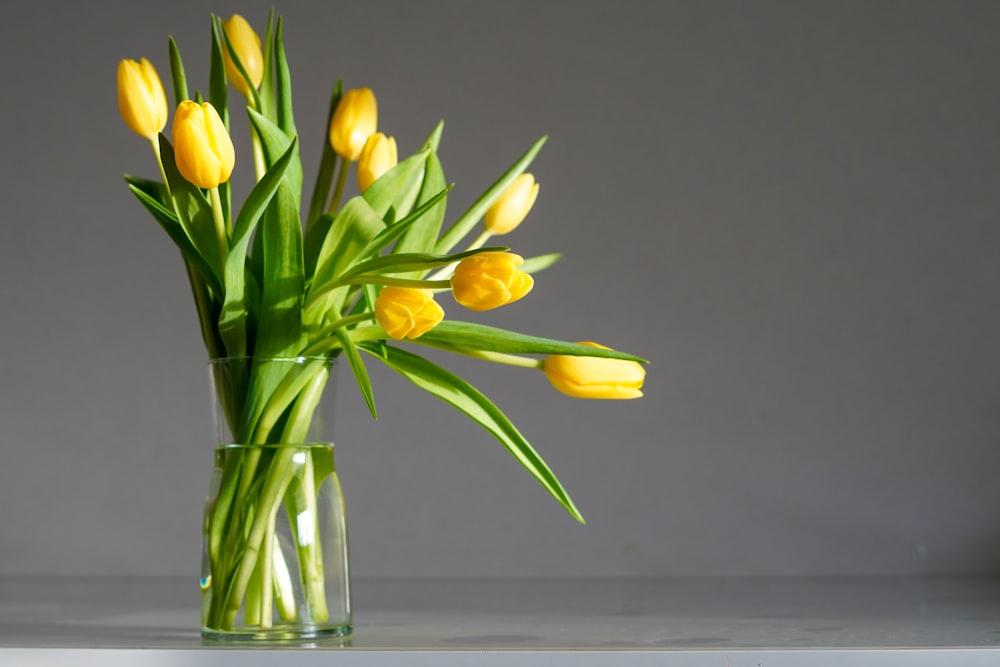 a vase filled with yellow flowers on top of a table