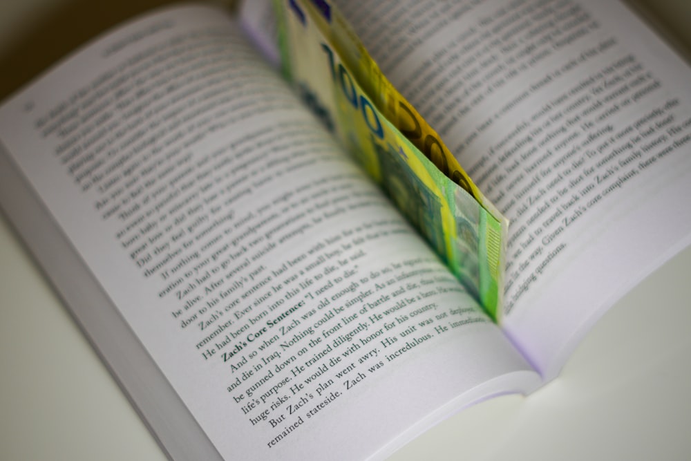 an open book with a folded piece of paper sticking out of it
