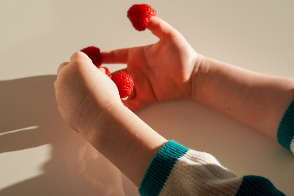 a person holding raspberries in their hands