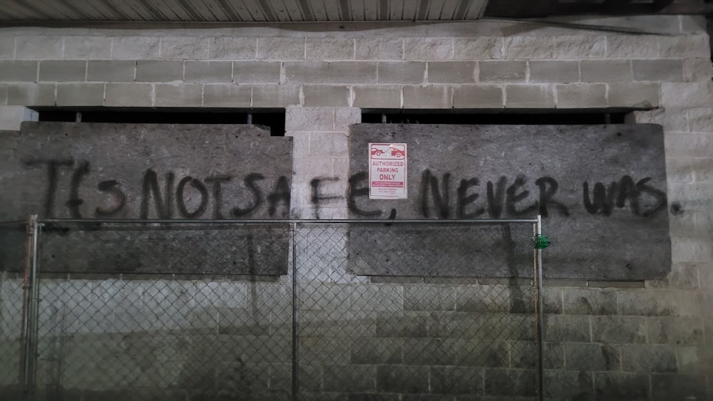 Grafitis en el costado de un edificio que dice que no es seguro entrar
