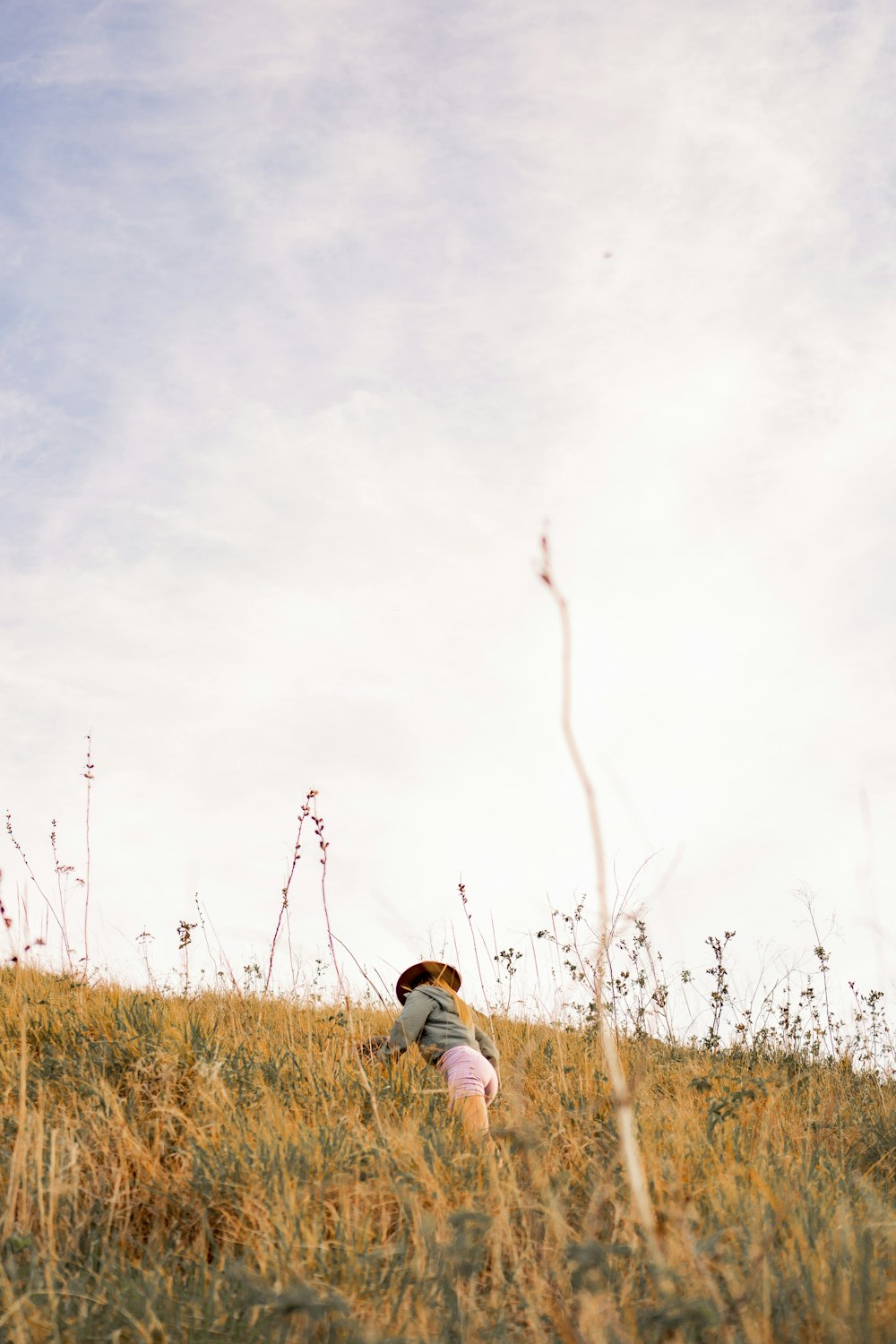 a person kneeling down in a field of tall grass