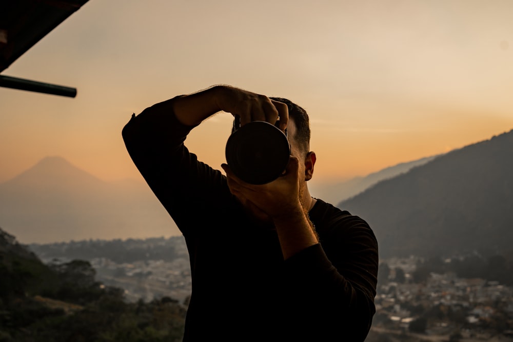 a man is taking a picture of the mountains