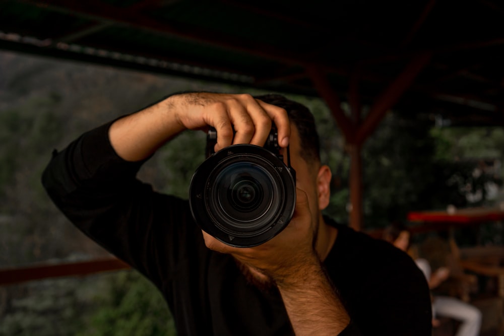a man holding a camera up to his face