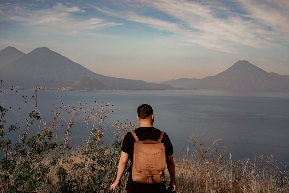 a man with a backpack is looking at the water