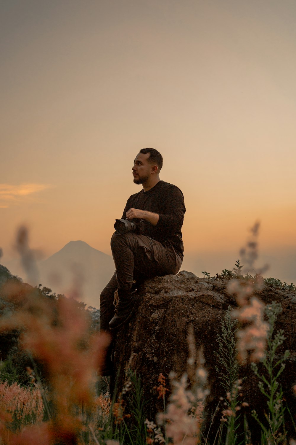 un hombre sentado en la cima de una gran roca