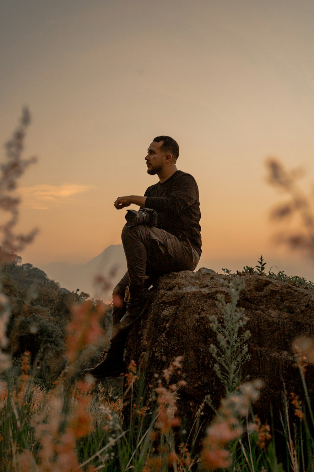 un uomo seduto in cima a una grande roccia