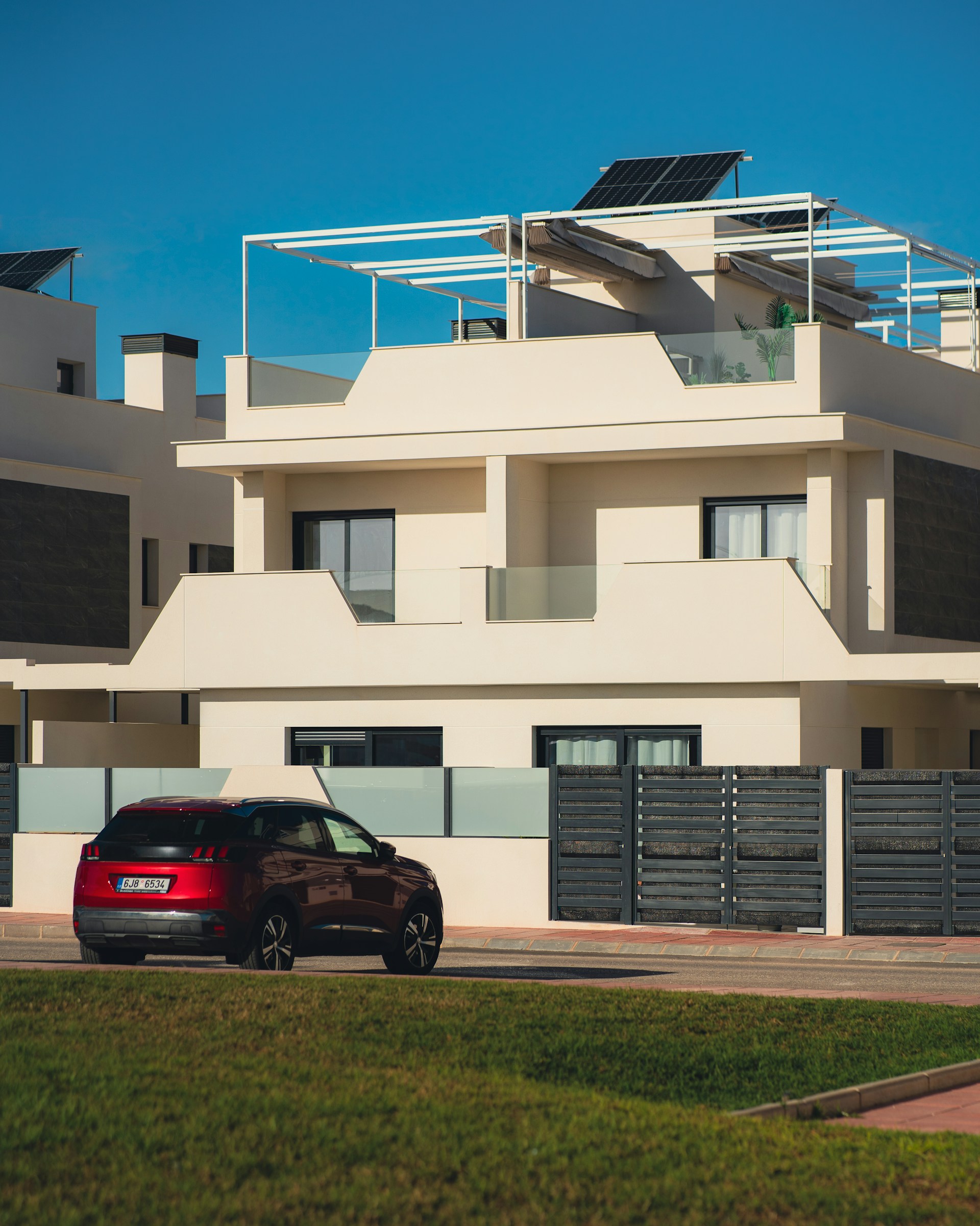 a red car parked in front of a white building