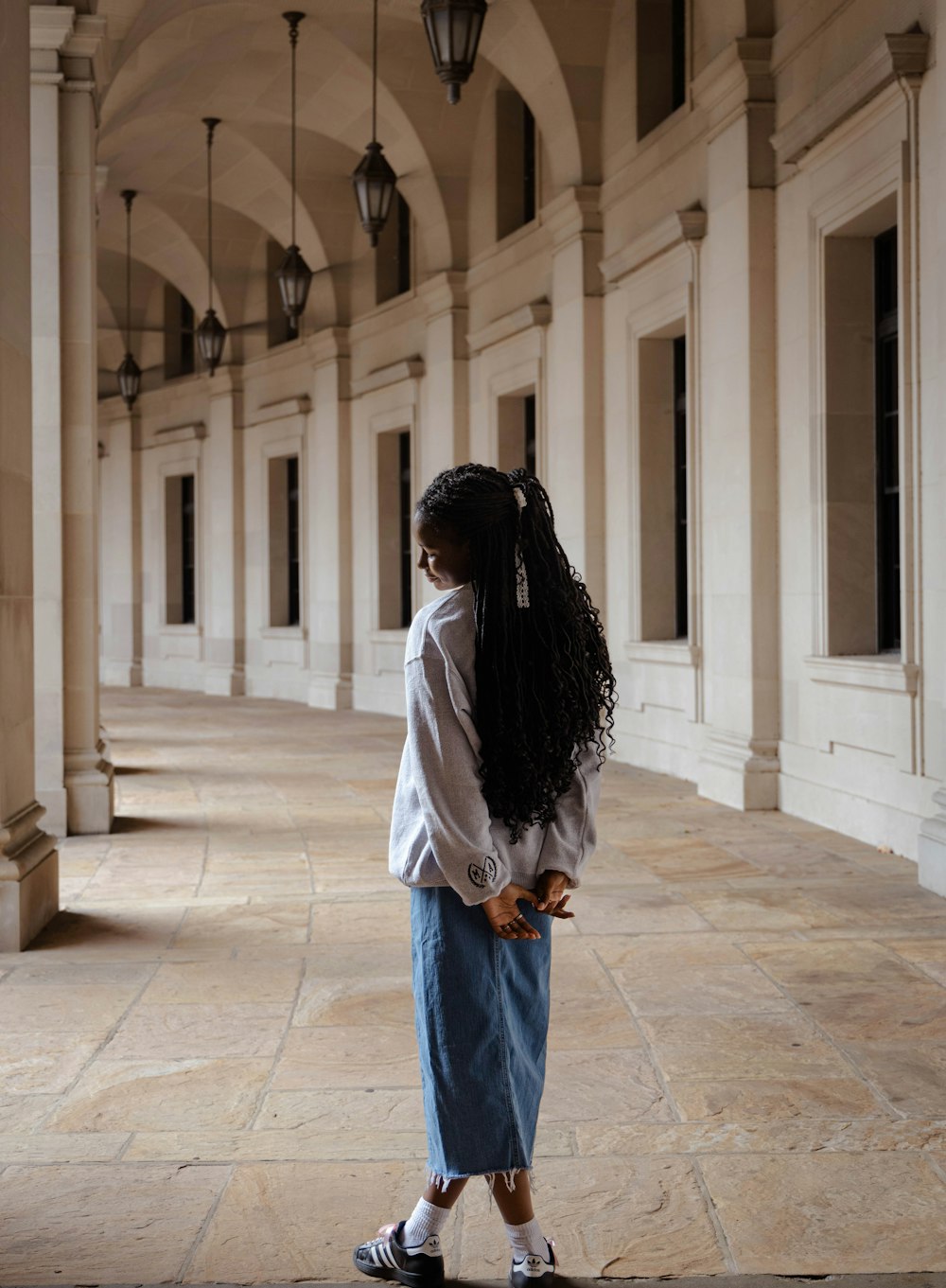 a woman with long hair standing in a hallway