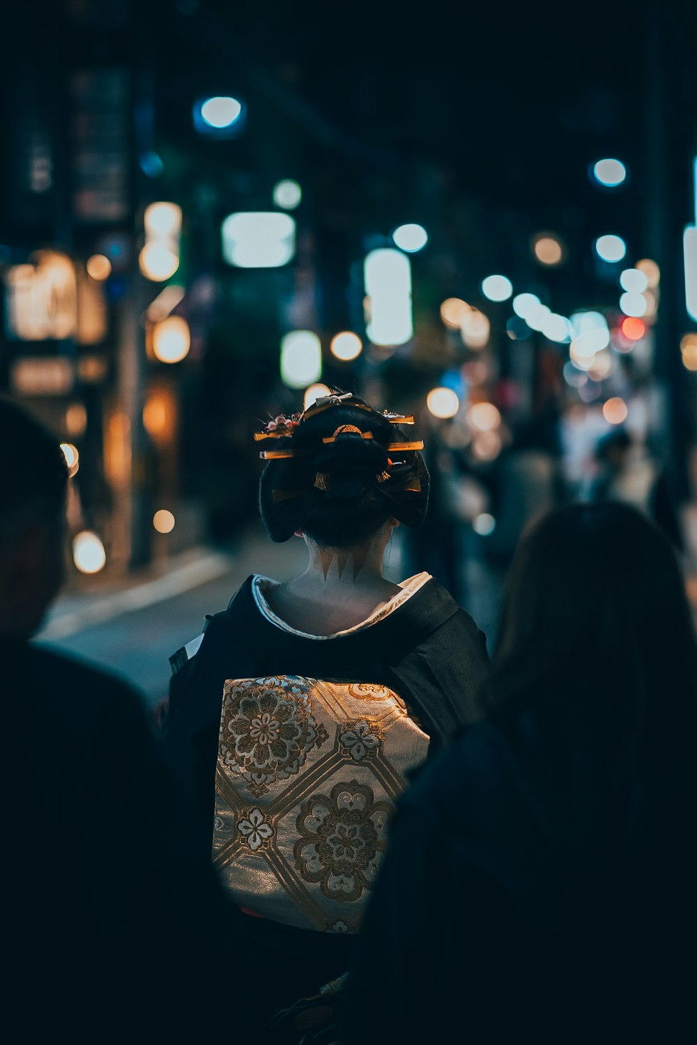 a woman walking down a street at night