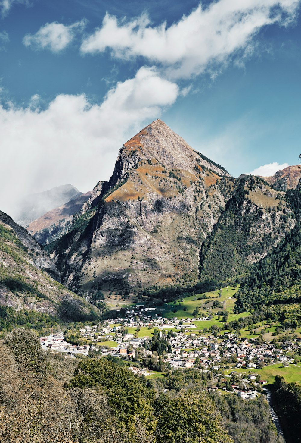 a scenic view of a town nestled in the mountains