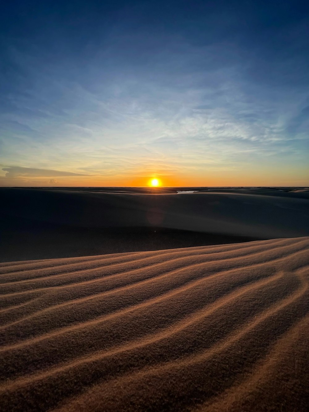 the sun is setting over the sand dunes