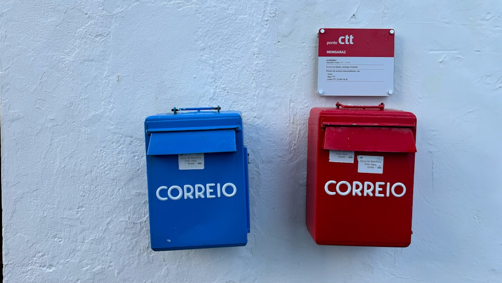 a couple of red and blue mail boxes next to each other