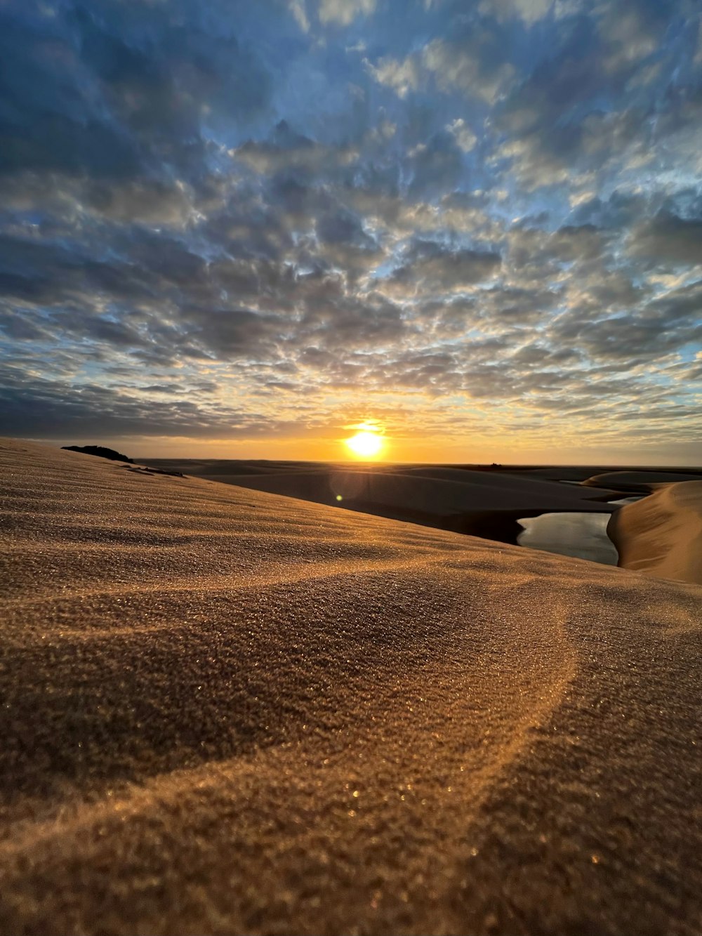 the sun is setting over the sand dunes