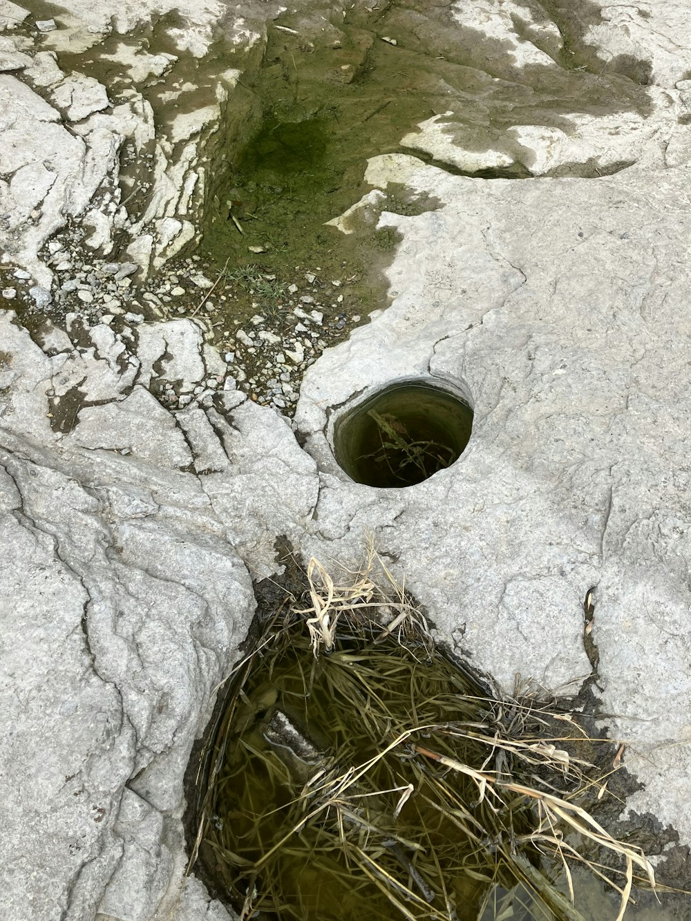 a hole in the rock with water coming out of it