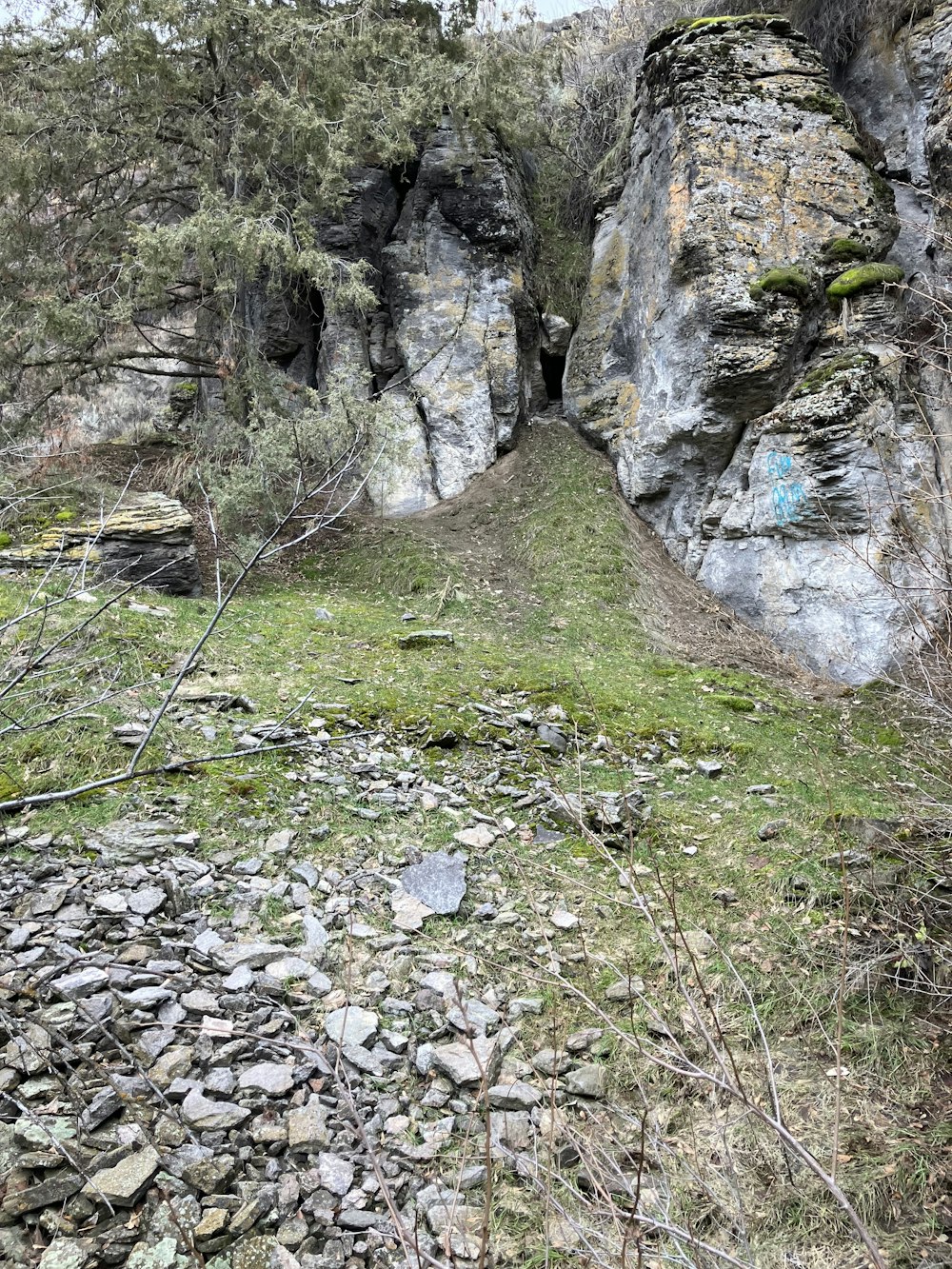 a large rock formation with a grassy area between it