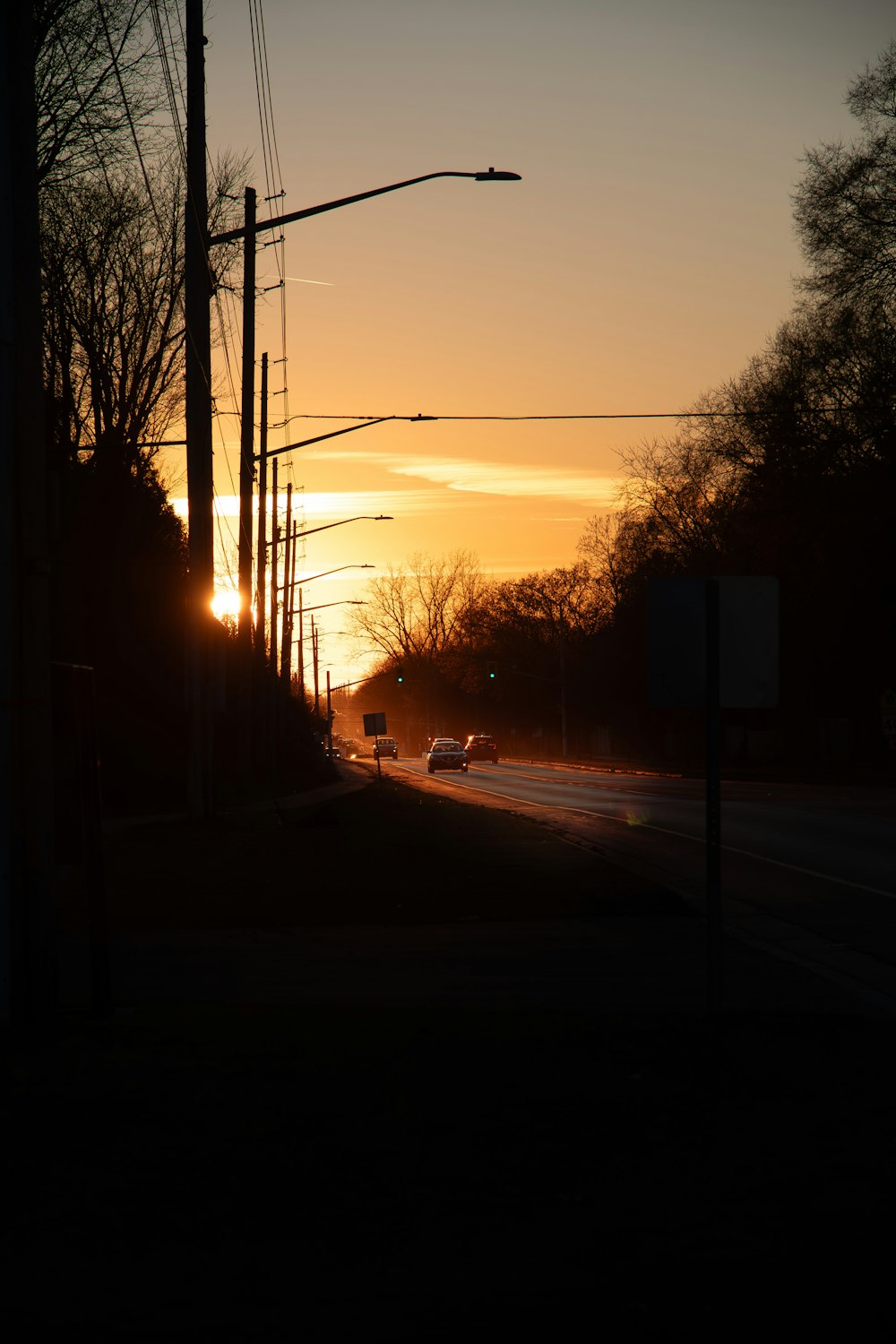 a car driving down a street at sunset