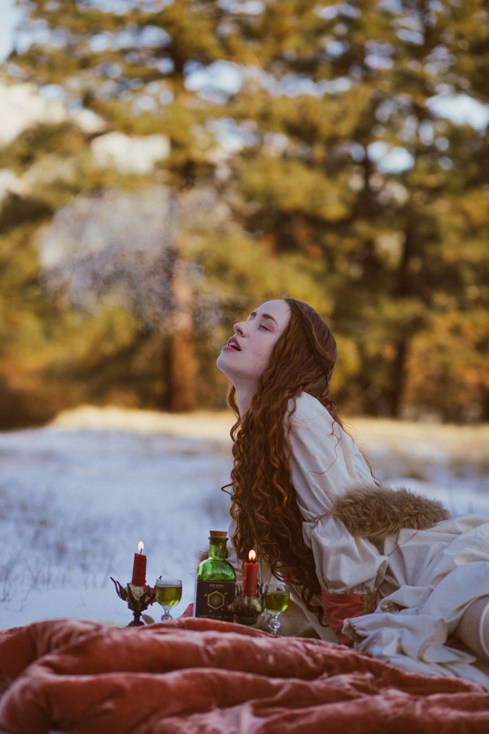 a woman sitting on a blanket in the snow