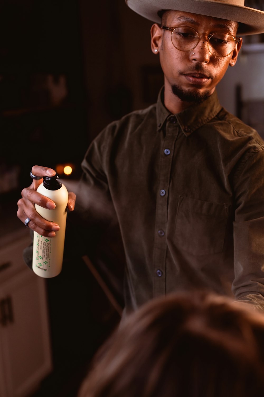 a man in a hat and glasses holding a bottle