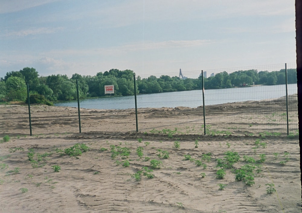 a fenced in area next to a body of water